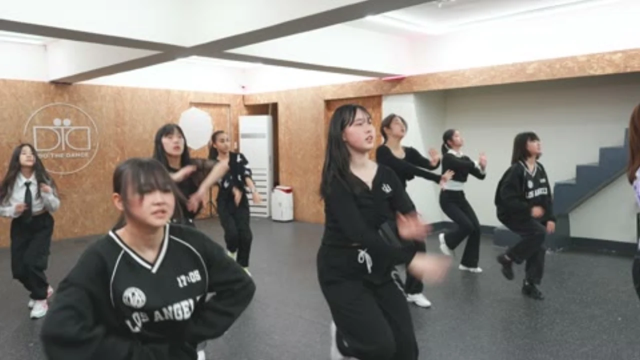 밝은 스튜디오에서 KPOP 군무를 연습하는 직장인 취미반 수강생들